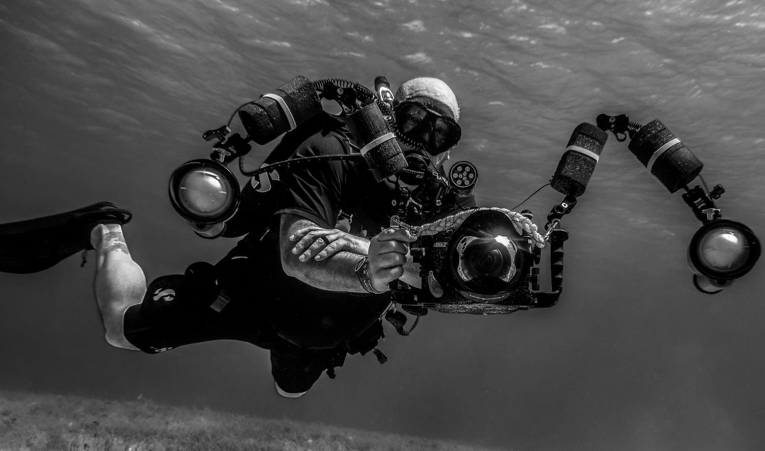 Diver with a housed camera in black and white